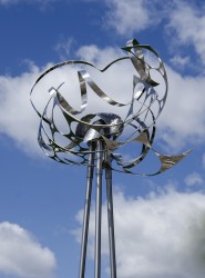 Ribbons and latticed shapes of polished stainless steel in this outdoor sculpture, when seen from below, glint sharply and offer a contrast …