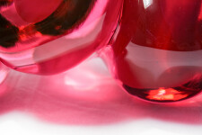 Clustered and sensuous oblong forms in translucent red glass have a smooth polished surface like the fruit that surrounds pomegranate seeds. Image 10