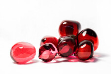 Clustered and sensuous oblong forms in translucent red glass have a smooth polished surface like the fruit that surrounds pomegranate seeds. Image 3