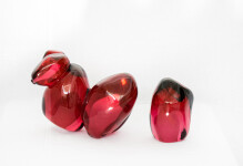 Clustered and sensuous oblong forms in translucent red glass have a smooth polished surface like the fruit that surrounds pomegranate seeds. Image 4