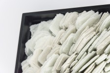 Layered petals of white glass frit are composed within a black lacquer frame by artist Cheryl Wilson-Smith. Image 4