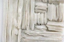 Wafers of cool white glass frit are layered and stacked in a curated wall relief by Cheryl Wilson Smith. Image 5