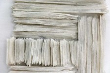 Wafers of cool white glass frit are layered and stacked in a curated wall relief by Cheryl Wilson Smith. Image 4