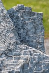 Concentric rings are carved on one side of this triangular chunk of limestone. Image 6