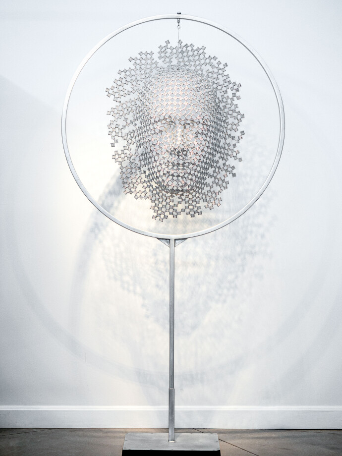 This contemporary metal sculpture of a mask is kinetic and was created by a Canadian artist.