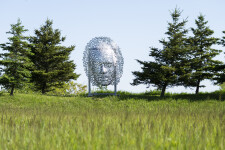 This contemporary wall sculpture of a mask is made out of metal. Image 5