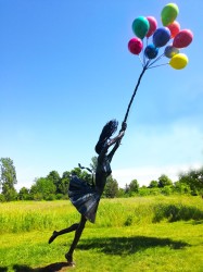 Rendered in fine detail, the figure of a young woman is carried upwards by colorful balloons in this provocative outdoor sculpture by Derya …