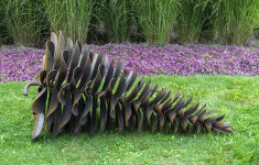 This contemporary outdoor sculpture was forged from steel; its form is inspired by nature. Image 2