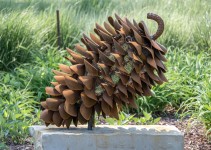 Hand forged from weathering steel Floyd Elzinga’s impressive outdoor sculpture of a pine cone is designed to house logs for a fire. Image 2