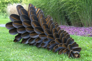 This contemporary outdoor sculpture was forged from steel; its form is inspired by nature.