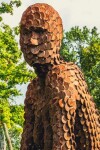 A seated female figure strikes a casual pose, body half turned in this imposing sculpture by American artist, Jason Kimes. Image 6