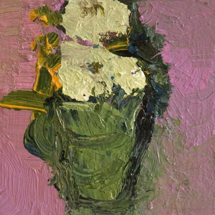 A bouquet of creamy coloured flowers in a sage green vase pops against a field of deep pink.