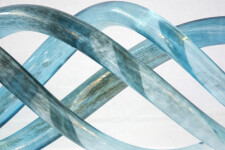 Four undulating lengths of smooth, translucent azure blue and charcoal glass move together in an elegant wave-like rhythm. Image 3