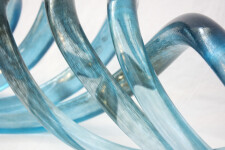 Four undulating lengths of smooth, translucent azure blue and charcoal glass move together in an elegant wave-like rhythm. Image 6