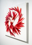 Crimson glass feathers are gathered into a fiery composition in this dramatic wall sculpture by artist John Paul Robinson. Image 3