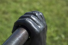 Like long arms, a set of two vertical copper pipes topped by bronze cast hands emerge from the ground. Image 2