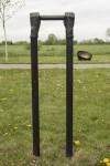 Like long arms, a set of two vertical copper pipes topped by bronze cast hands emerge from the ground. Image 5