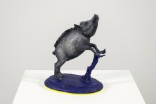 Cast in resin, a figurine of a boar posed on an indigo base points to a theme of human and animal interaction that includes taxidermy. Image 3