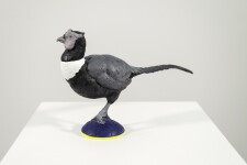 Cast in resin, a figurine of a pheasant posed on an indigo base points to a theme of human and animal interaction. Image 2