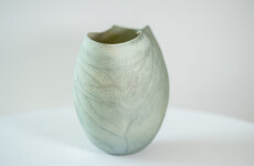 This contemporary ceramic vessel is moss green in color. Image 3