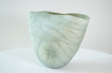 This contemporary ceramic vessel is moss green in color. Image 2