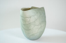 This contemporary ceramic vessel is moss green in color. Image 5