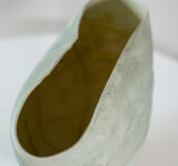 This contemporary ceramic vessel is moss green in color. Image 11