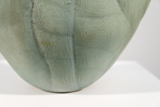 This contemporary ceramic vessel is moss green in color. Image 12