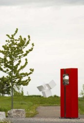 A polished stainless steel ball is framed by cardinal red in this outdoor geometric sculpture by French artist Philippe Pallafray.