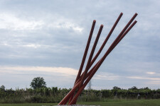 This contemporary orange-colored metal outdoor sculpture is the work of Shayne Dark. Image 2