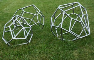 Every angle is made visible in the three polygonal boulder shapes constructed of steel tube in this outdoor sculpture installation.