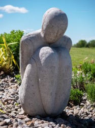 The stark simplicity of this small figure seated on the ground in a silent, prostrate pose evokes a deep emotional response.