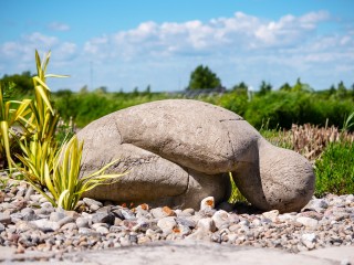 The stark simplicity of this small figure seated on the ground in a silent, prostrate pose evokes a deep emotional response.