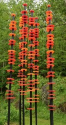 The beauty of hand blown glass rings in glowing reds and oranges shine in the sunlight in this delightful outdoor sculpture by Susan Rankin.